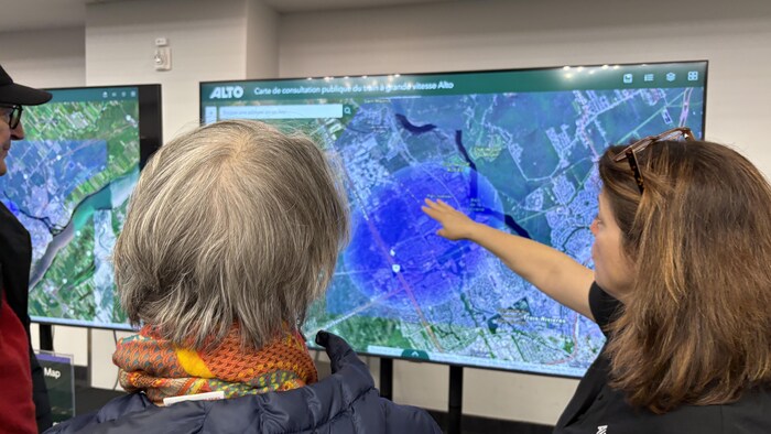 Des personnes regardent une carte sur un écran