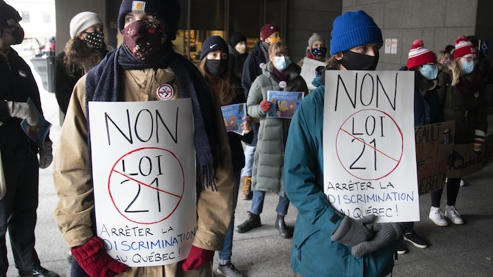 Demonstrators against Bill 21, the province's secularism law, are seen holding signs outside Quebec Superior Court. A challenge to the law will be heard at the Quebec Court of Appeal in November. 