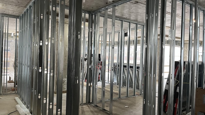 Les cloisons de métal en train d'être installées dans l'édifice.