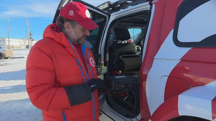 Andrew Comrie-Picard, membre de l'équipe Transglobal Car Expedition, montre la technologie utilisée pour ajuster la pression des pneus de camion.