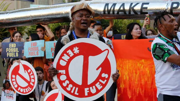 Des militants participent à une manifestation contre les combustibles fossiles pendant la COP 28 à Dubaï.