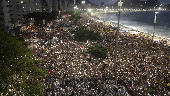Des personnes assistent à l'« Ato Musical pela Democracia » (Manifestation musicale pour la démocratie), un concert organisé en faveur de la démocratie, sur la plage de Copacabana à Rio de Janeiro, au Brésil, le 18 octobre 2026, une semaine avant le second tour de l'élection présidentielle.