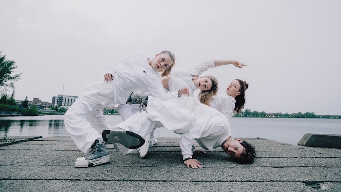 Les danseurs du CopperCrib dans une pose élaborée, en mouvement, au bord du lac Osisko.