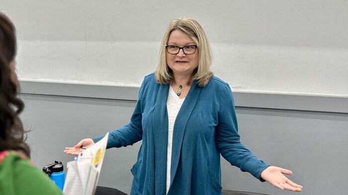 Coreen Corcoran gesticule lors d'une prise de parole.