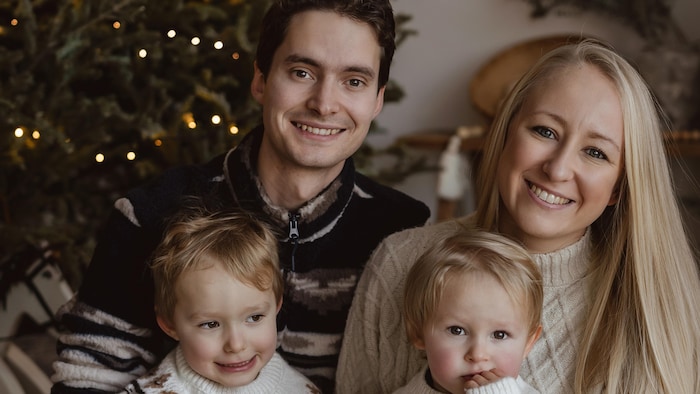 Une famille devant un arbre de Noël.