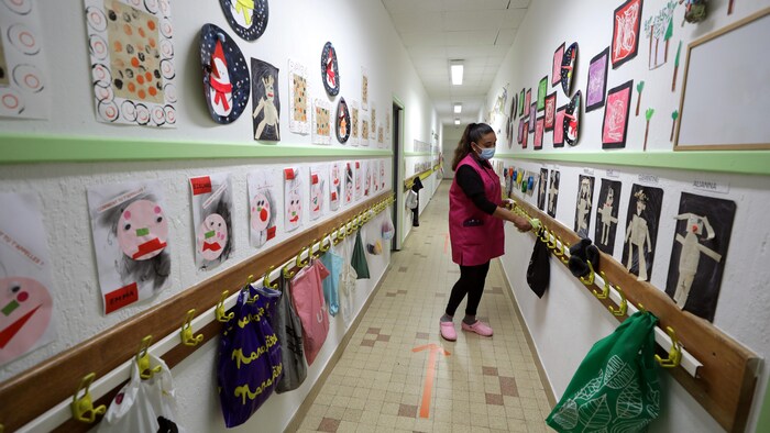 Une employée désinfecte le couloir d'une école de Nice, en France.