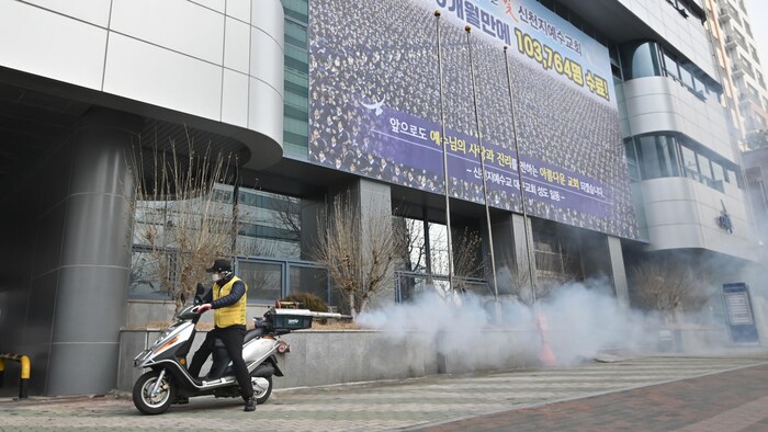 Des mobylettes sont utilisées pour répandre du désinfectant devant les locaux de l'Église Shincheonji de Jésus, un important foyer de coronavirus.