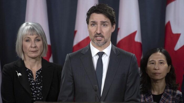 Au centre, se tient Justin Trudeau. À gauche, la ministre de la Santé, Patty Hajdu, et à droite, l'administratrice en chef de la santé publique du Canada, la Dre Theresa Tam.