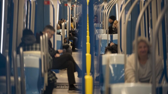 Des personnes assises dans le métro à Montréal.