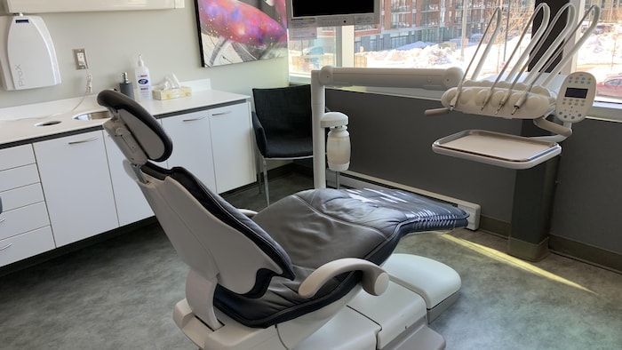 Une chaise de dentiste vide dans un bureau.