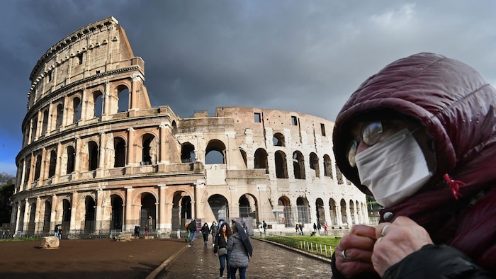  Un homme portant un masque de protection passe devant le Colisée, à Rome. 