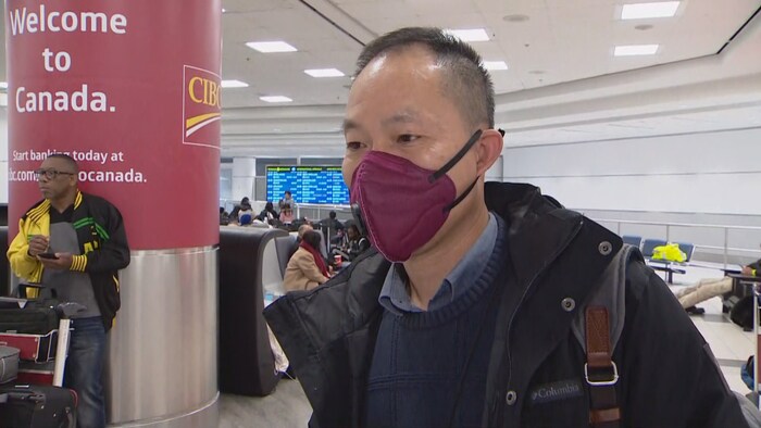 Un homme en entrevue qui porte un masque couvrant sa bouche.