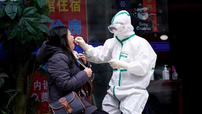 Une journaliste de l'agence Reuters ouvre la bouche pour subir un test de dépistage pour la COVID-19 à Wuhan, en Chine.