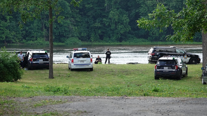 Des policiers inspectent les berges de la rivière des Prairies.