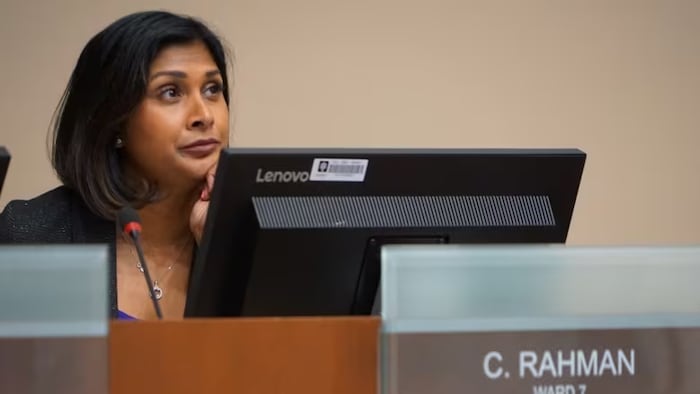 Corrine Rahman, assise, regarde vers le haut.