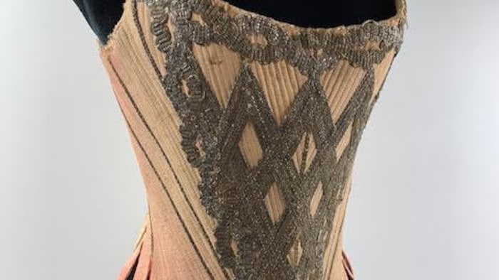 Un corset de soie avec des galons or et argent.