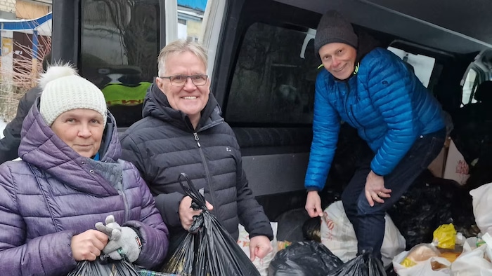 Ed Dickson (en noir) et le père de Cory Jones, Bob Jones (en bleu) sont en train de distribuer des provisions aux Ukrainiens qui vivaient le long de la ligne de front en 2023.