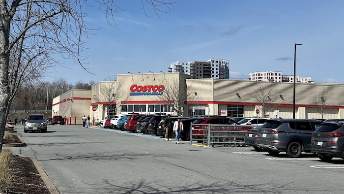 La façade d'un entrepôt Costco avec des voitures dans le stationnement.