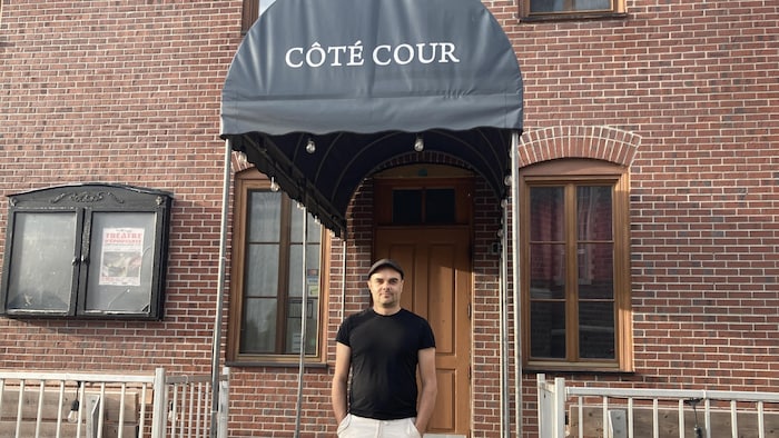 Dario Larouche se trouve devant l'entrée du Côté-Cour, de Jonquière.