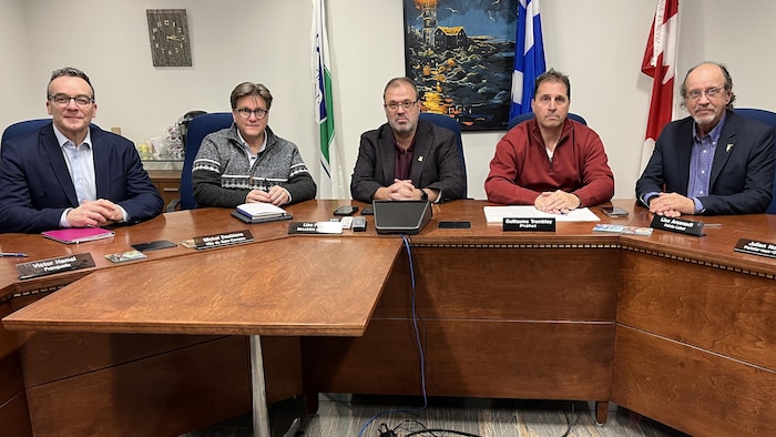 Guy Simard, Yves Montingy, Michel Desbiens, Guillaume Tremblay et Julien Normand sont assis autour d'une table. 