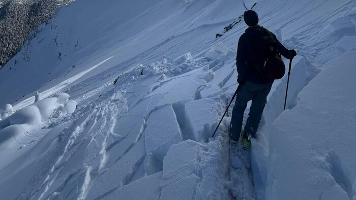 Un skieur sur une couche de neige brisée. 
