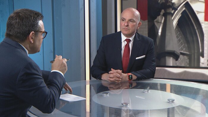 Daniel Thibeault et Randy Boissonnault discutent autour d'une table.