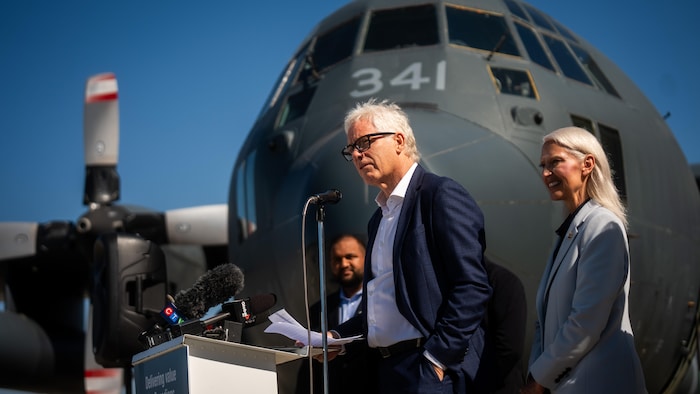 Wayne Coulson devant un avion.