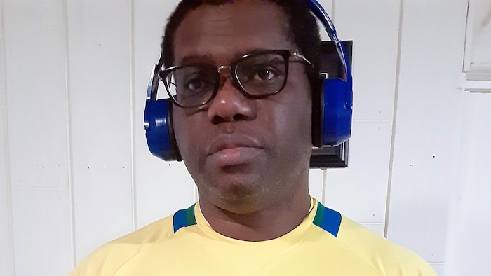 Cédric Engone regarde vers la caméra avec un casque audio sur la tête.