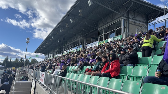 Des spectateurs assistent à la coupe de la mairesse.