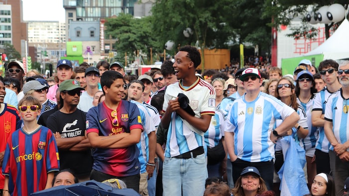 Un partisan enfile un maillot de l'Espagne par-dessus celui de l'Argentine.