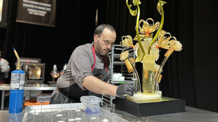 Le pâtissier Nicolas Belorgey complète sa sculpture de sucre lors de la sélection nationale de l'équipe canadienne de la Coupe du monde de la pâtisserie à Toronto le 7 avril 2025.
