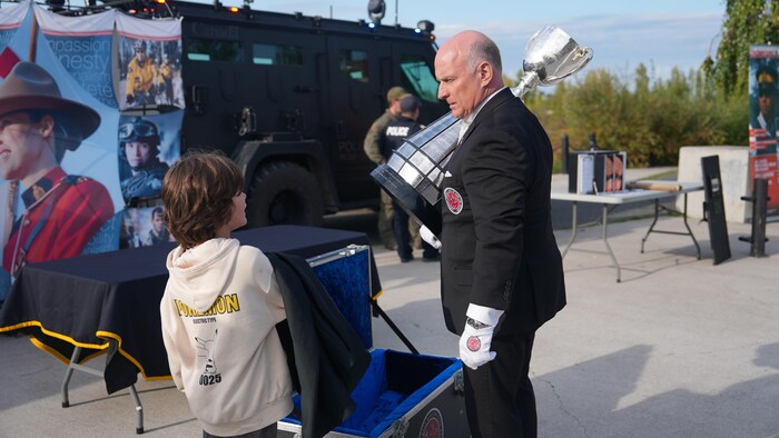 Jeff Mcwhinney portant la coupe avec un enfant à ses côtés.