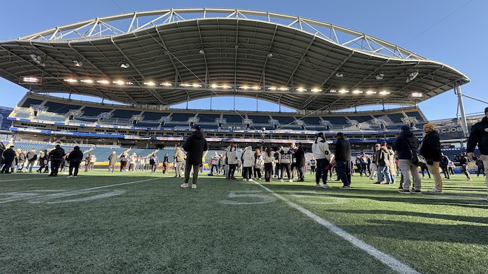 Photo prise en plan large de l'intérieur du stade alors que des gens y socialisent.