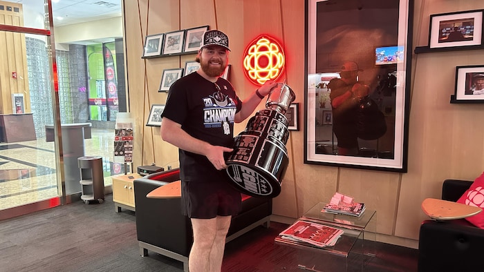 Alex Cousineau tient un trophée dans ses mains.