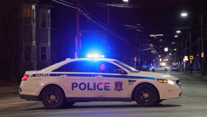 سيارتان لشرطة هاليفاكس الإقليمية تغلقان جزءاً من أحد شوارع وسط المدينة ليلاً خلال إحدى العمليات.