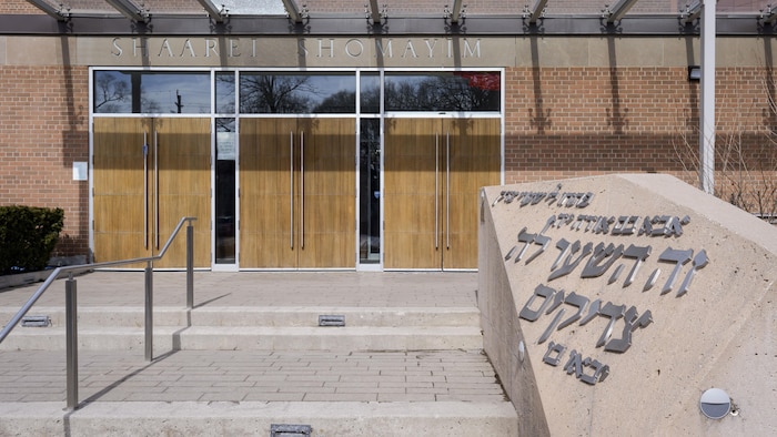 Des impacts de balles marquent les portes d'entrée de la synagogue Shaarei Shomayim, à North York, en Ontario, le 9 mars 2026, après une attaque nocturne — la troisième fusillade contre un lieu de culte juif en une semaine.