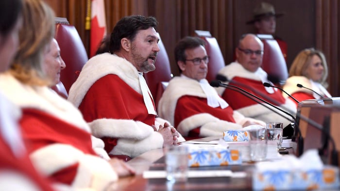 Sept juges de la Cour suprême siègent à une table.