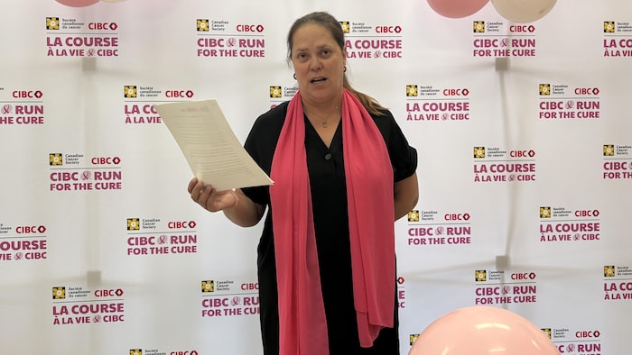 Danielle Périgny, debout et feuille en main, s'adresse aux gens.
