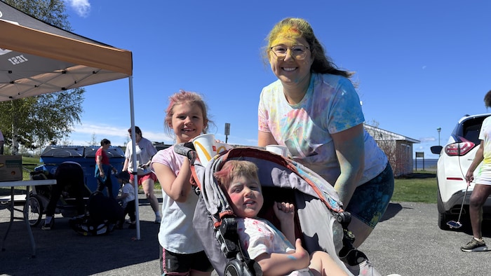 Chloée Cormier et ses deux enfants, souriants, sont couverts de couleurs.