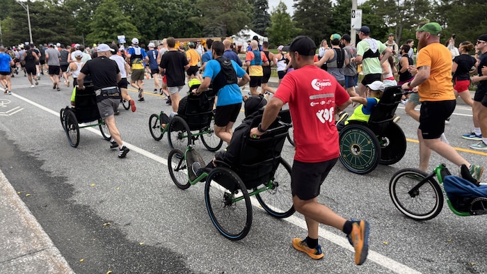 Des personnes se font pousser dans un fauteuil.