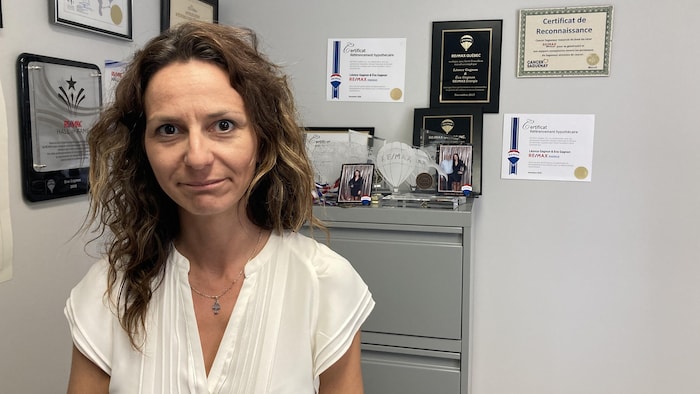 Une femme dans son bureau avec ses diplômes.