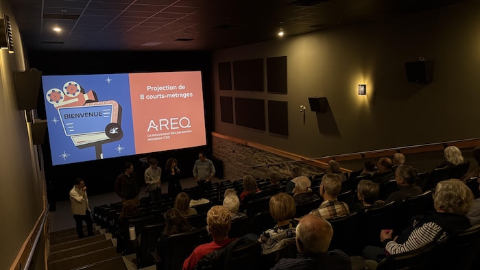 Des aînés sont assis dans une salle de cinéma.