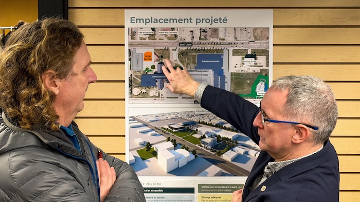 Benoit Méthot pointe un emplacement sur une carte. Un citoyen l'observe.
