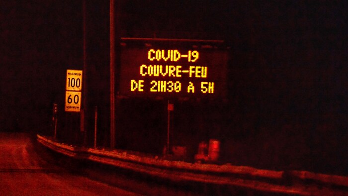 Un panneau lumineux signale les heures du couvre-feu en bord d'autoroute.