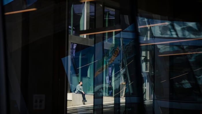 A woman sits in the sun under the Granville Street bridge in Vancouver on March 30, 2022. Women accounted for 47.3 per cent of Canada's workforce in February. 