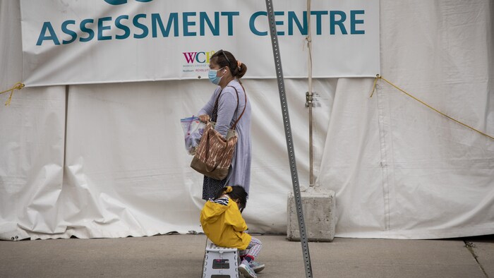 Une femme et son enfant attendent à un centre de dépistage de Toronto.