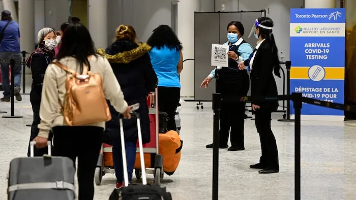 Travellers move through Toronto's Pearson Airport earlier this month. Canadians taking trips longer than 72 hours and foreign travellers entering Canada will still have to show proof of a negative molecular test taken within 72 hours of their departing flight or planned arrival at the land border. 