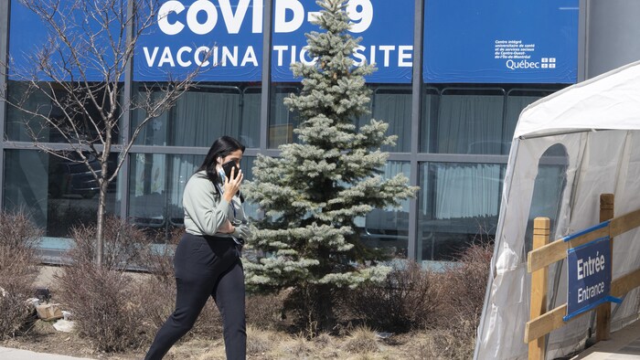 امرأة تمرّ من أمام مركز للتطعيم ضدّ وباء كوفيد-19 في مونتريال.