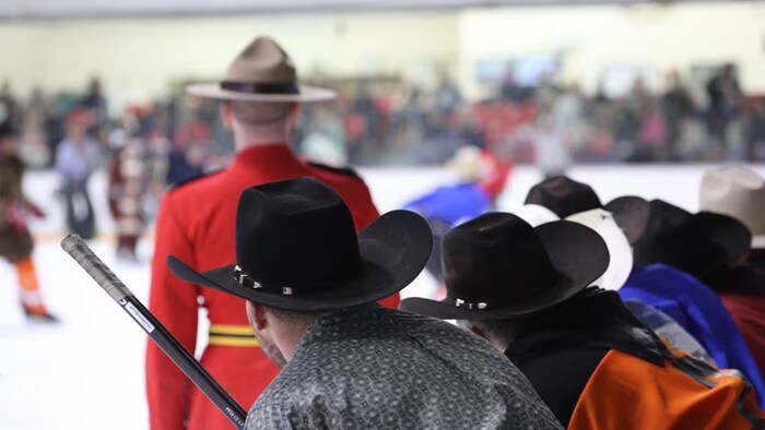 Des joueurs de hockey habillés en cowboys, sur un banc.