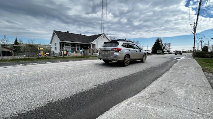 Une voiture circule sur la rue Sainte-Cécile-du-Bic et passe devant le CPE du village du Bic.